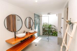 a bathroom with two sinks and two mirrors at Hotel Libreria Cafe de Pombal in Santa Marta +108 photos