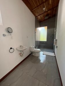 een badkamer met een toilet, een wastafel en een douche bij Villa Republik in Parrita