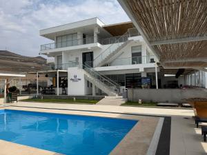 a building with a swimming pool in front of a building at Vista a Mar in Huaral