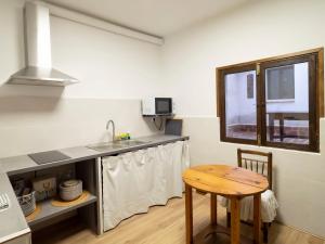 een kleine keuken met een tafel en een wastafel bij Casa de La Canita in Guadamur +27 foto's