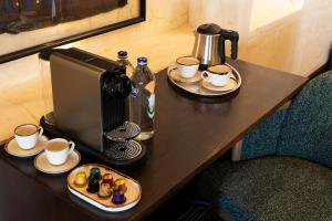 een tafel met een koffiezetapparaat en kopjes koffie bij Zerzembe Boutique Hotel in Sanlıurfa