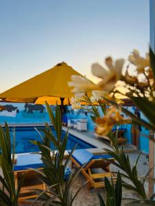 a pool with chairs and an umbrella on the beach at Horus Golden Luxor in Luxor