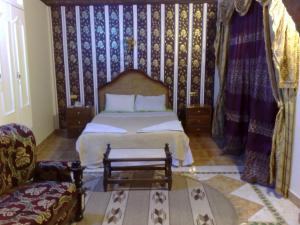 a bedroom with a bed and a chair in it at Old Oasis Hotel for Safari Trips in Az Zabū +40 photos