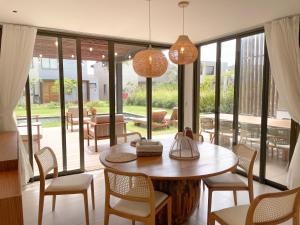 a dining room with a table and chairs and a large window at The house - Casa Coral in Trairi