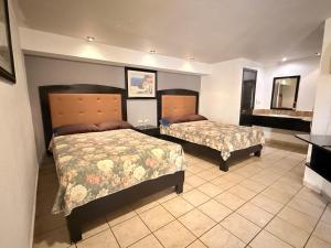 a hotel room with two beds and a mirror at Hotel la Finca Inn in Matamoros +19 photos