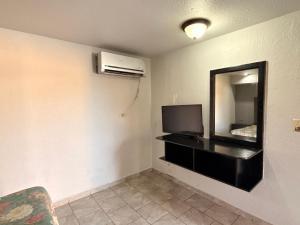 a living room with a television and a mirror at Hotel la Finca Inn in Matamoros
