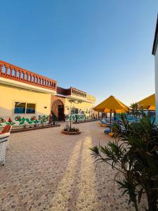 a resort courtyard with chairs and umbrellas on a beach at Horus Golden Luxor in Luxor +53 photos