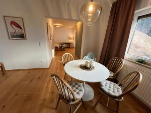 een eetkamer met een witte tafel en stoelen bij Apartment Laura in Jenig +18 foto's
