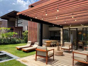 a wooden deck with chairs and a table and a building at The house - Casa Coral in Trairi