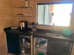 a kitchen counter with a sink and a window at Casa para Reveillon - cururupe in Ilhéus