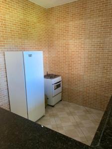 a kitchen with a white refrigerator and a stove at Casa para Reveillon - cururupe in Ilhéus +9 photos