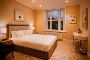 een hotelkamer met een bed en een raam bij The Hadley Hotel in New Barnet