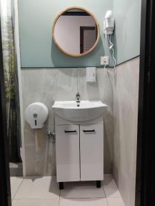 une salle de bain avec un lavabo et un miroir au mur dans l'établissement VIKI Kazimierz, à Cracovie 102 autres photos