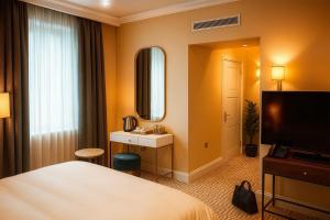 een hotelkamer met een bed en een spiegel bij The Hadley Hotel in New Barnet