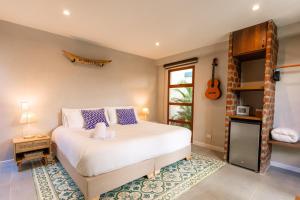 a bedroom with a bed and a guitar on the wall at Hotel Libreria Cafe de Pombal in Santa Marta