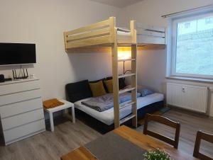 een kleine kamer met een stapelbed en een bank bij Apartmán Denisa in Rokytnice nad Jizerou