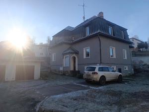 een witte auto geparkeerd voor een huis bij Apartmán Denisa in Rokytnice nad Jizerou