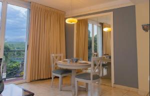 a dining room with a table and chairs and a window at Altos de Fontana by Macondo Collection in Managua