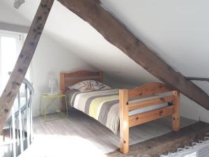 una camera da letto con letto in legno in mansarda di L'atypique a Lignières