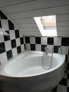 eine weiße Badewanne in einem Badezimmer mit Dachfenster in der Unterkunft Ferienwohnung DFranz in Weitefeld + 2 Fotos