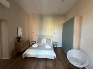 ein Schlafzimmer mit einem Bett, einem Stuhl und einem Spiegel in der Unterkunft Domis Napoli in Neapel