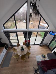 a living room with a table and chairs and large windows at Arbor in Vadul lui Carol II