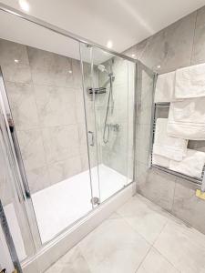een douche met een glazen deur in een badkamer bij The Hadley Hotel in New Barnet +37 foto's
