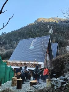 een groep mensen die voor een gebouw zitten bij the clifton chapter tirthan in Banjār