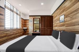 een slaapkamer met een groot bed en 2 stoelen bij Prm classic lodge in Erode