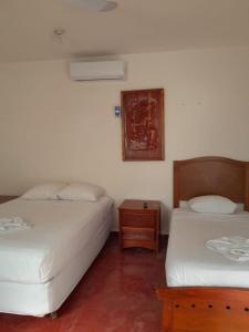 ein Schlafzimmer mit zwei Betten und einem Nachttisch in der Unterkunft Hotel Casa Zued chichen itza in Pisté
