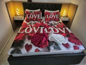 een bed met hartjes en de woorden liefde bij APARTMENt ANAYA in Bovec