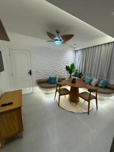a living room with a table and a couch at Praia do Rosa Park Studio in Guarapari