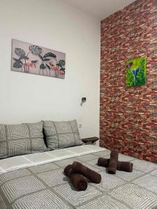 une chambre avec un lit et un mur de briques dans l'établissement Lotus house, à Zrenjanin