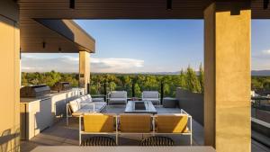 a patio with a table and chairs on a balcony at Landing Modern Studio Rooftop Lounge Gym in Englewood