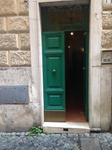 ローマにあるSmall Navona Studioの石壁の建物内の緑の扉