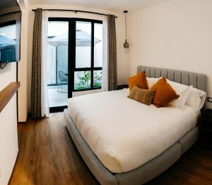 een slaapkamer met een groot wit bed en een raam bij Casa Castillo Condesa in Mexico-Stad