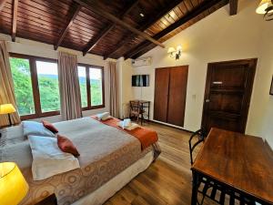 een slaapkamer met een groot bed en een tafel bij Hotel Selva Montana in San Lorenzo