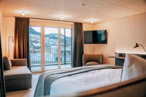 ein Hotelzimmer mit Bett und Balkon in der Unterkunft Roggenstock Lodge in Oberiberg