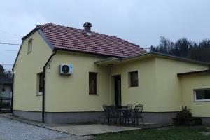 una casa bianca con tavolo e sedie di Kuća za odmor Dankica a Veliko Trgovišće