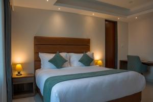 a hotel room with a large bed and two lamps at Hotel De Blossom in Guwahati