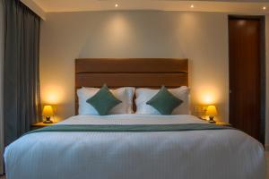 a bedroom with a large white bed with two lamps at Hotel De Blossom in Guwahati
