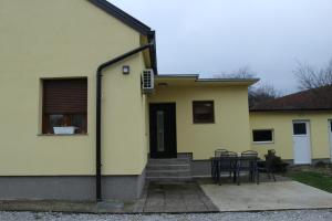 een geel huis met een tafel en stoelen bij Kuća za odmor Dankica in Veliko Trgovišće