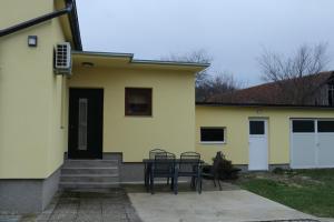 een geel huis met een tafel en stoelen ervoor bij Kuća za odmor Dankica in Veliko Trgovišće