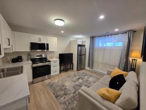 un salon avec un canapé et une cuisine dans l'établissement Quiet Comfort Suite, à Moncton