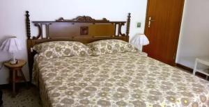 a bed with a wooden headboard and two pillows at B&B Amurri Domenica in Grottammare