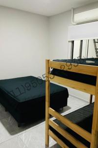 een slaapkamer met twee stapelbedden en een ladder bij Bertioga Rio da Praia in Bertioga