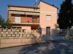 a pink house with a white fence in front of it at B&B Amurri Domenica in Grottammare