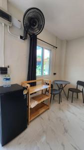 a room with a table and a fan on the wall at Sarin Guesthouse สาริน in Koh Tao +54 photos