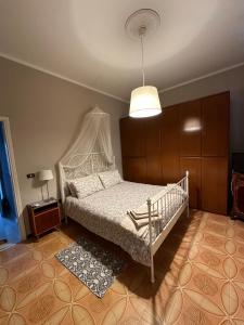a bedroom with a white bed and a lamp at La Fatina appartamento in Collodi