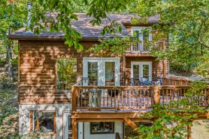 een huis met een terras met stoelen erop bij Almost Heaven - Grill, 2 King Beds, Wifi, Deck, Pool Access, Hiking, Wood Stove, Family Friendly in Berkeley Springs